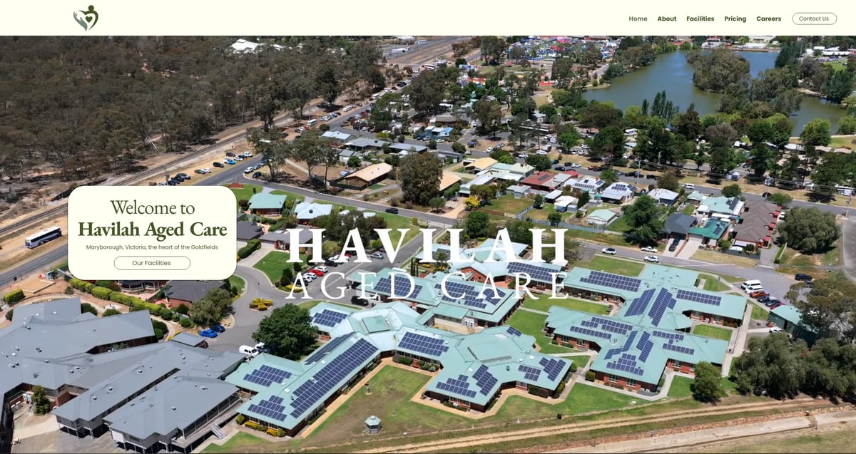 Aerial view of Havilah Aged Care facility with modern blue-roofed buildings, pools, and surrounding residential area near a river